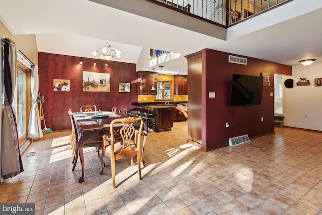 tiled dining space with a notable chandelier and high vaulted ceiling