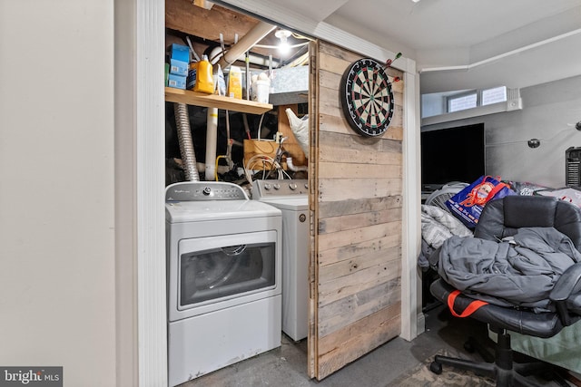 laundry area with independent washer and dryer and wooden walls