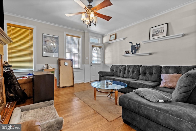 living room with light hardwood / wood-style flooring, ceiling fan, and crown molding