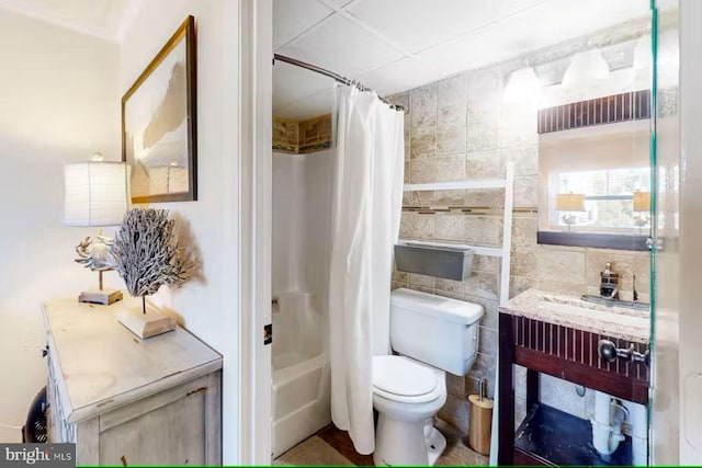 bathroom with toilet, shower / bathtub combination with curtain, and tile walls