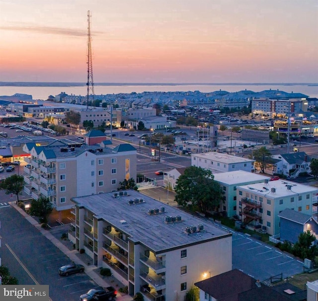 aerial view at dusk featuring a water view