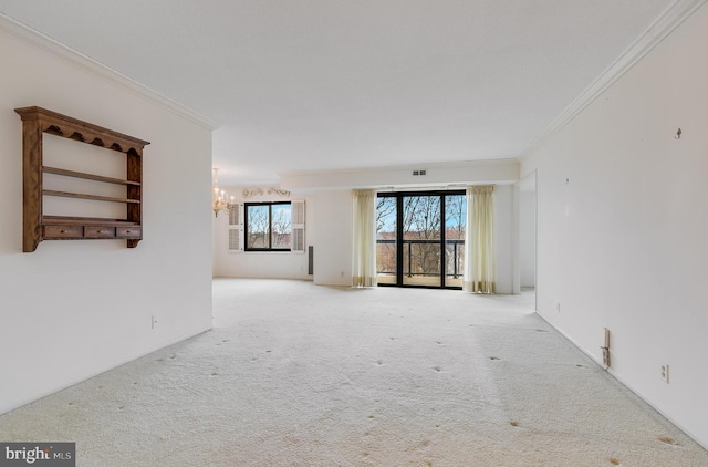 carpeted empty room featuring ornamental molding and a notable chandelier