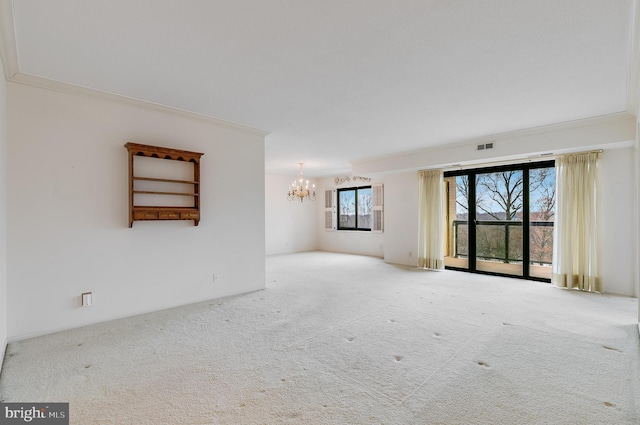 spare room featuring a notable chandelier, crown molding, and light carpet