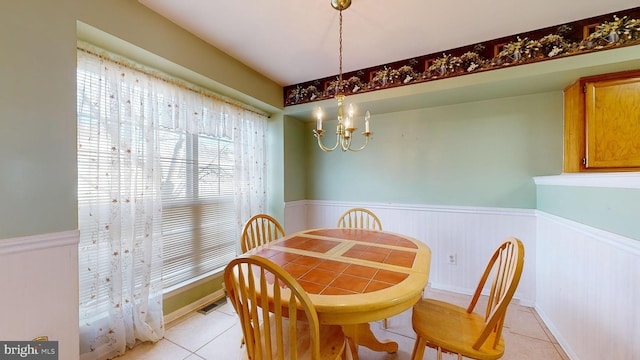 dining space with light tile patterned floors and a chandelier