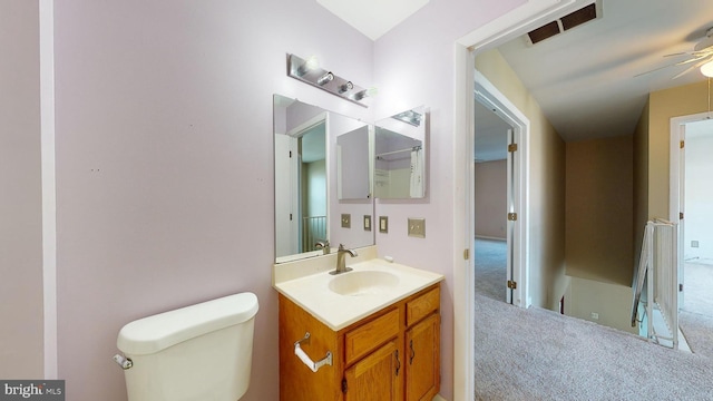 bathroom featuring toilet, vanity, and ceiling fan