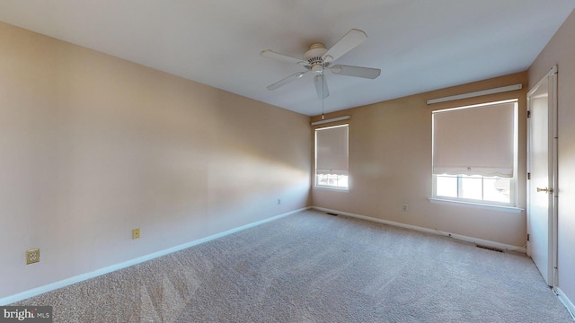 spare room with ceiling fan and light carpet