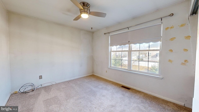 carpeted spare room featuring ceiling fan