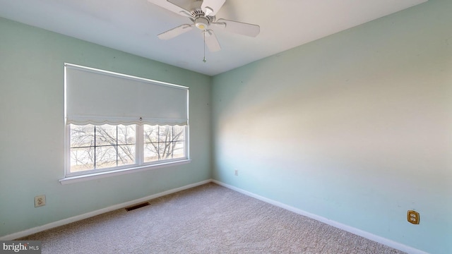 unfurnished room with ceiling fan and carpet