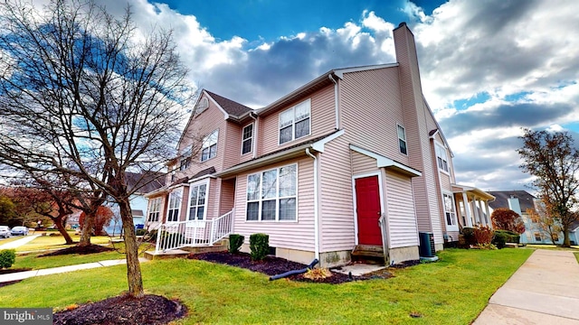 view of front facade featuring central AC unit and a front yard