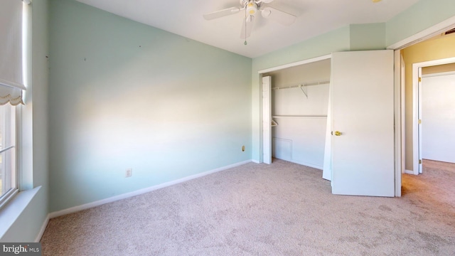 unfurnished bedroom featuring ceiling fan, light colored carpet, and a closet