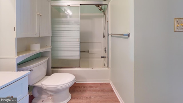 full bathroom with wood-type flooring, shower / bath combination with glass door, vanity, and toilet