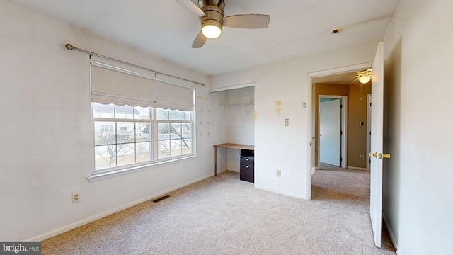 unfurnished bedroom featuring ceiling fan, a closet, and light carpet