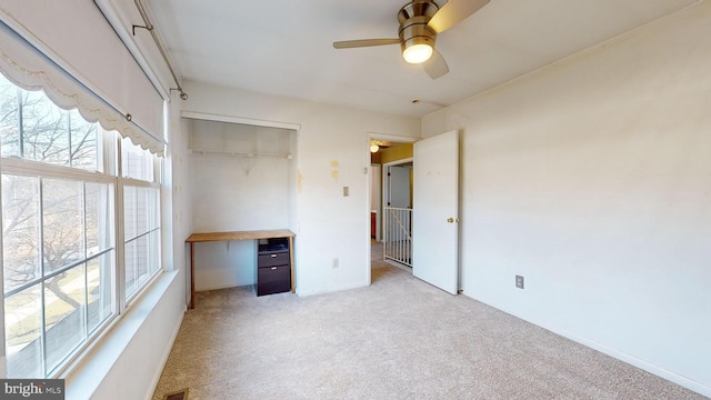 unfurnished bedroom featuring light carpet, multiple windows, a closet, and ceiling fan