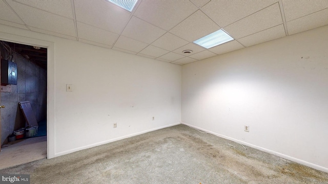 carpeted empty room with a drop ceiling