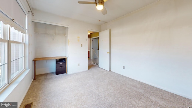 unfurnished bedroom with a closet, ceiling fan, and light colored carpet