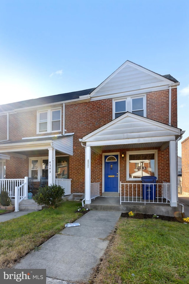 view of front of property with covered porch and a front yard