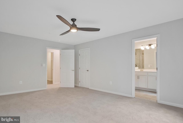 unfurnished bedroom featuring ensuite bathroom, sink, ceiling fan, and light colored carpet