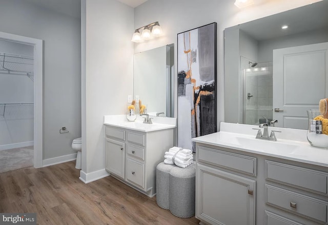 bathroom featuring vanity, toilet, hardwood / wood-style flooring, and an enclosed shower