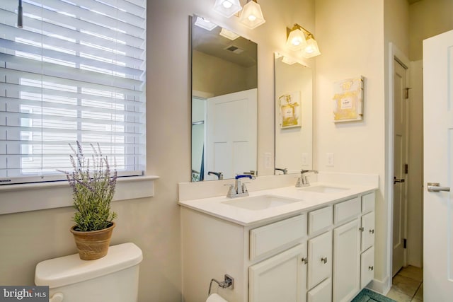 bathroom featuring tile patterned flooring, vanity, and toilet