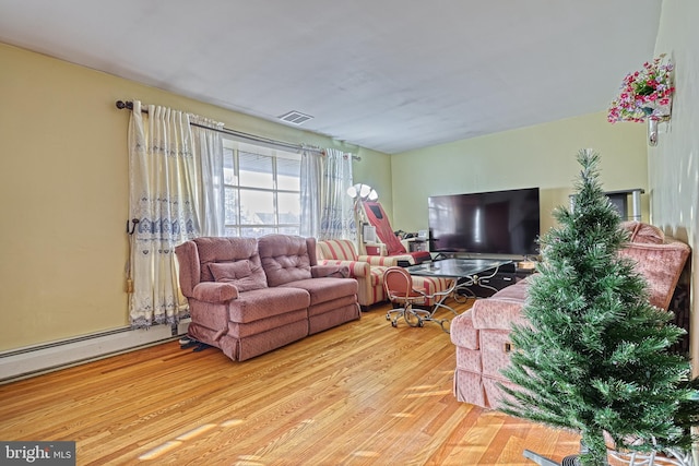 living room with light hardwood / wood-style floors and a baseboard heating unit