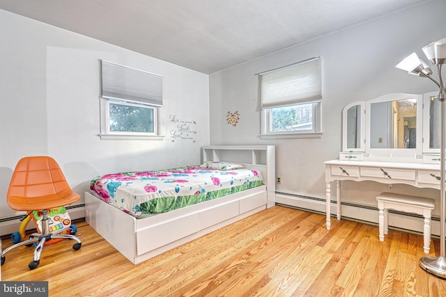 bedroom featuring light hardwood / wood-style flooring and a baseboard heating unit