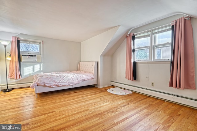 unfurnished bedroom with a baseboard heating unit, light wood-type flooring, and multiple windows