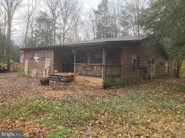 rear view of house with a porch and a shed