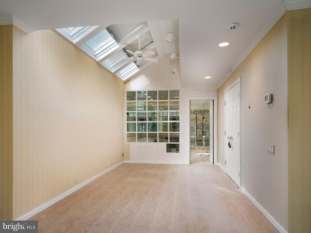 spare room with ceiling fan, crown molding, carpet floors, and lofted ceiling with skylight