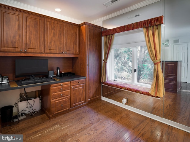 office space featuring ornamental molding, built in desk, and wood-type flooring