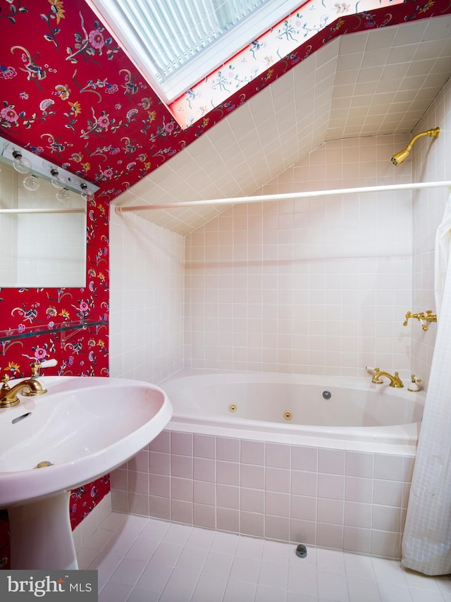 bathroom featuring tiled shower / bath combo, tile patterned floors, lofted ceiling, and sink