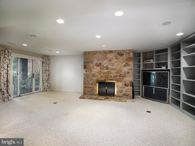 unfurnished living room with carpet flooring and a stone fireplace