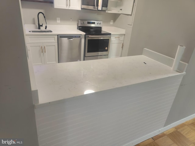 kitchen featuring white cabinets, appliances with stainless steel finishes, and sink