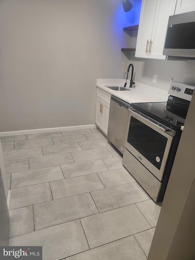 kitchen featuring light tile patterned flooring, sink, white cabinetry, and stainless steel appliances