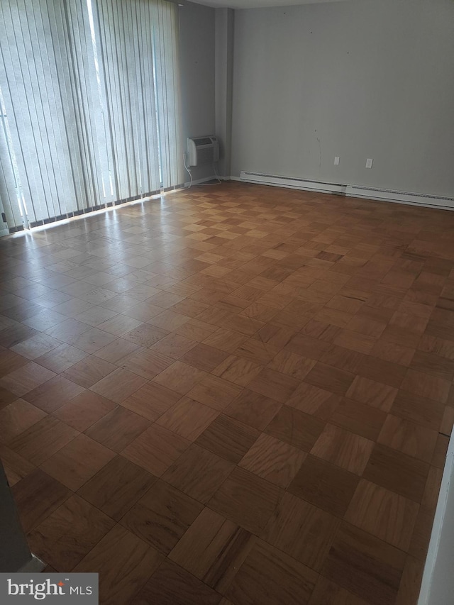 spare room featuring baseboard heating and a wall mounted air conditioner