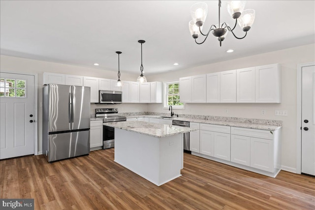 kitchen with pendant lighting, white cabinets, sink, and appliances with stainless steel finishes