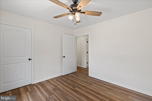 empty room featuring ceiling fan and dark hardwood / wood-style floors