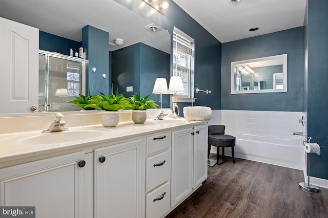 bathroom featuring hardwood / wood-style flooring, vanity, and plus walk in shower