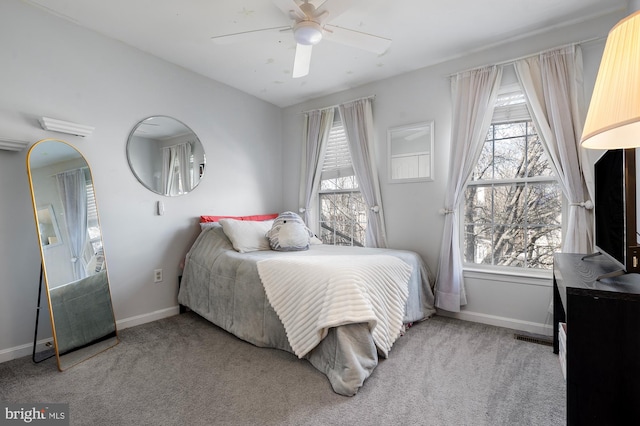 carpeted bedroom featuring ceiling fan and multiple windows