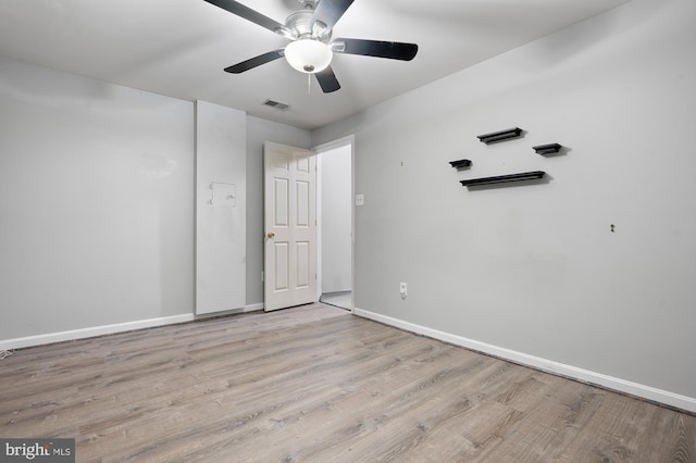 empty room with ceiling fan and light hardwood / wood-style floors