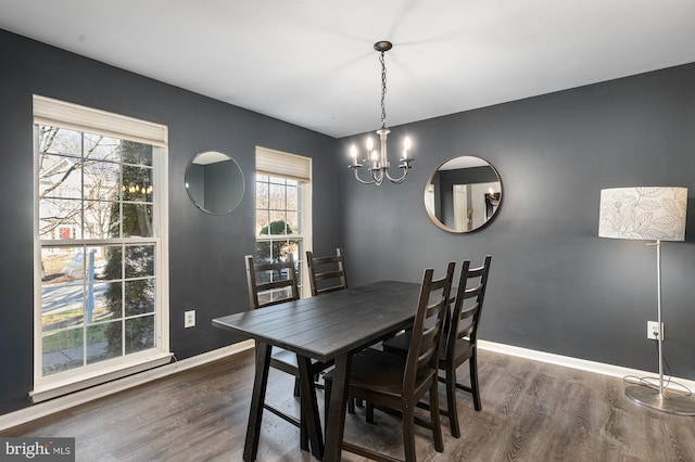 dining space featuring dark hardwood / wood-style flooring and a notable chandelier