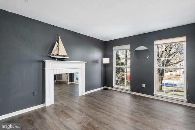 unfurnished living room with hardwood / wood-style floors and a healthy amount of sunlight