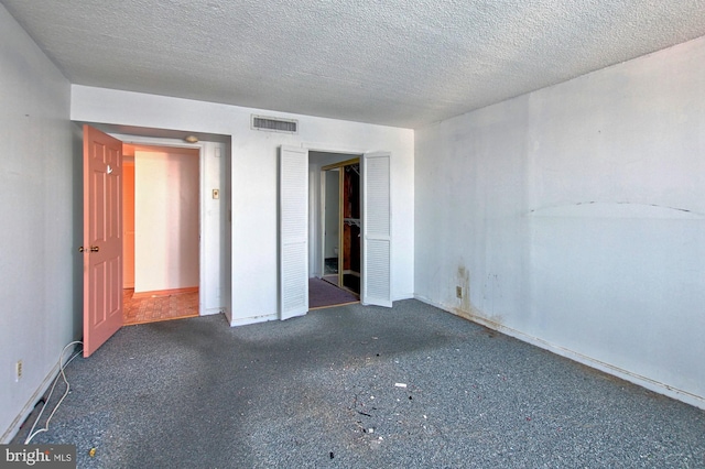 unfurnished bedroom with a textured ceiling and a closet