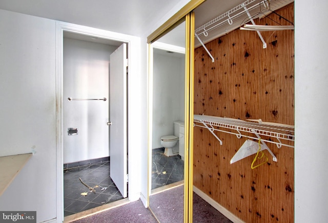 walk in closet featuring dark tile patterned flooring