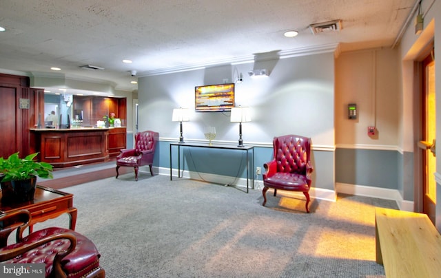 sitting room featuring a textured ceiling, light colored carpet, and ornamental molding