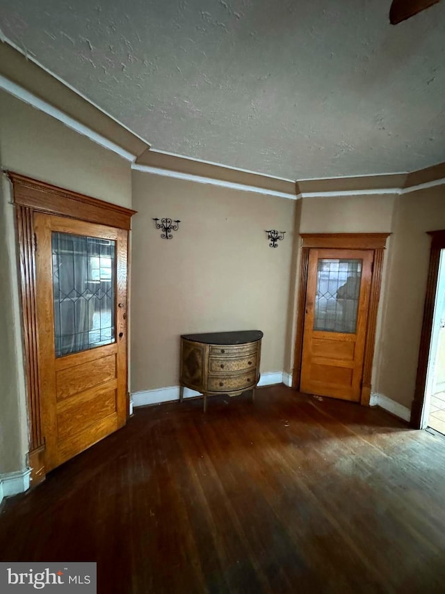 entryway with dark hardwood / wood-style floors and ornamental molding