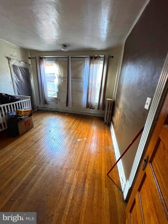 spare room with wood-type flooring and radiator