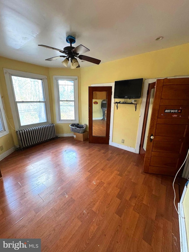 unfurnished bedroom with radiator and hardwood / wood-style floors