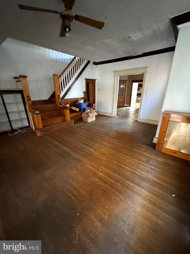 unfurnished living room with ceiling fan and dark hardwood / wood-style flooring