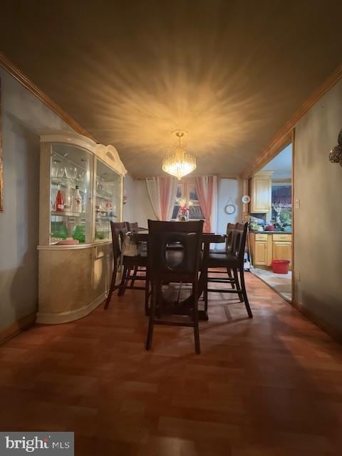 dining space featuring wood-type flooring, ornamental molding, and an inviting chandelier