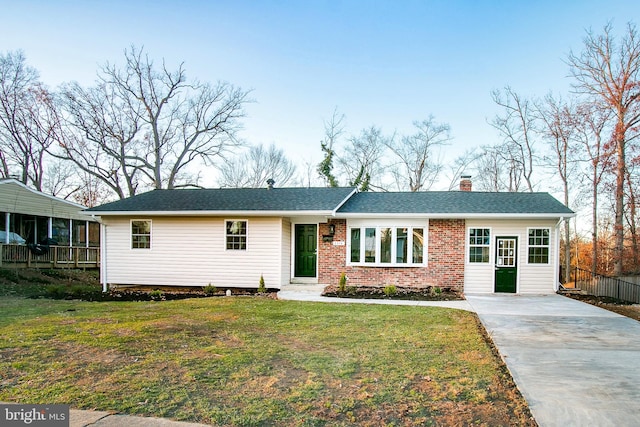 ranch-style house featuring a front lawn and a sunroom